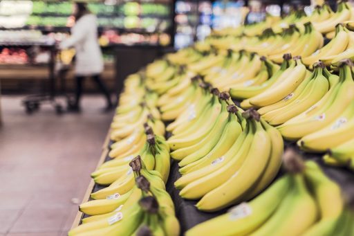 Spaarmuntjes van een supermarkt spaarprogramma naast een spaarbankje op een keukentafel