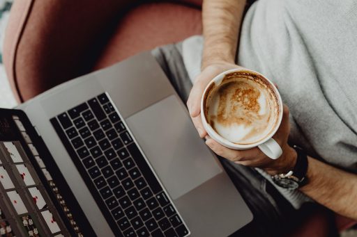 Persoon werkt aan laptop aan keukentafel en rekent aan digitale diensten