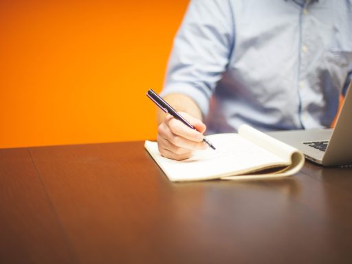 Persoon die financiën plant met notitieblok en rekenmachine op tafel