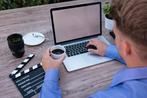 Jonge ondernemer die werkt op een laptop in een koffiebar