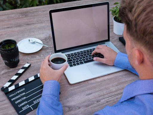 Jonge ondernemer die werkt op een laptop in een koffiebar