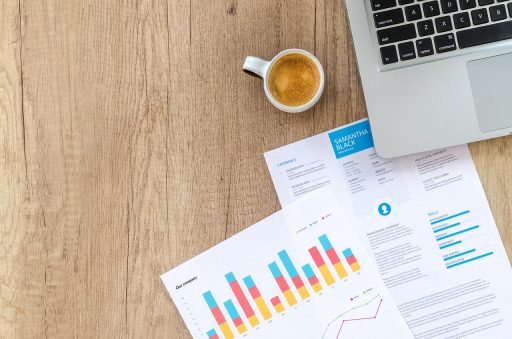Persoon die financiële documenten en grafieken doorneemt aan een bureau voor vermogensopbouw