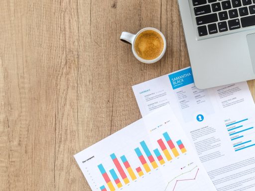 Persoon die financiële documenten en grafieken doorneemt aan een bureau voor vermogensopbouw