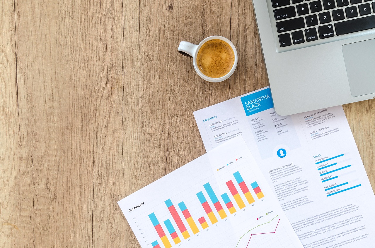 Persoon die financiële documenten en grafieken doorneemt aan een bureau voor vermogensopbouw
